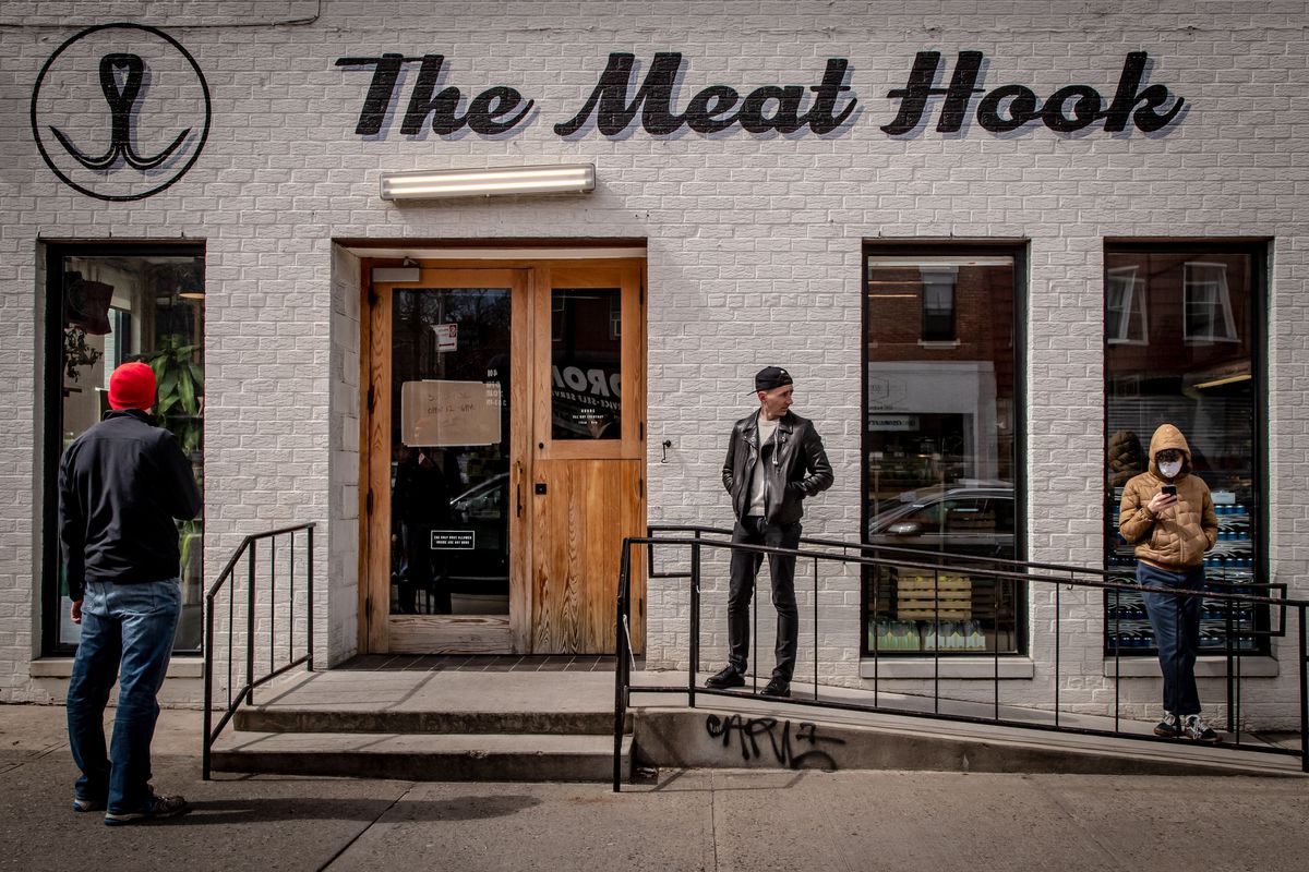 Customers wait in line outside The Meat Hook with social distancing between them