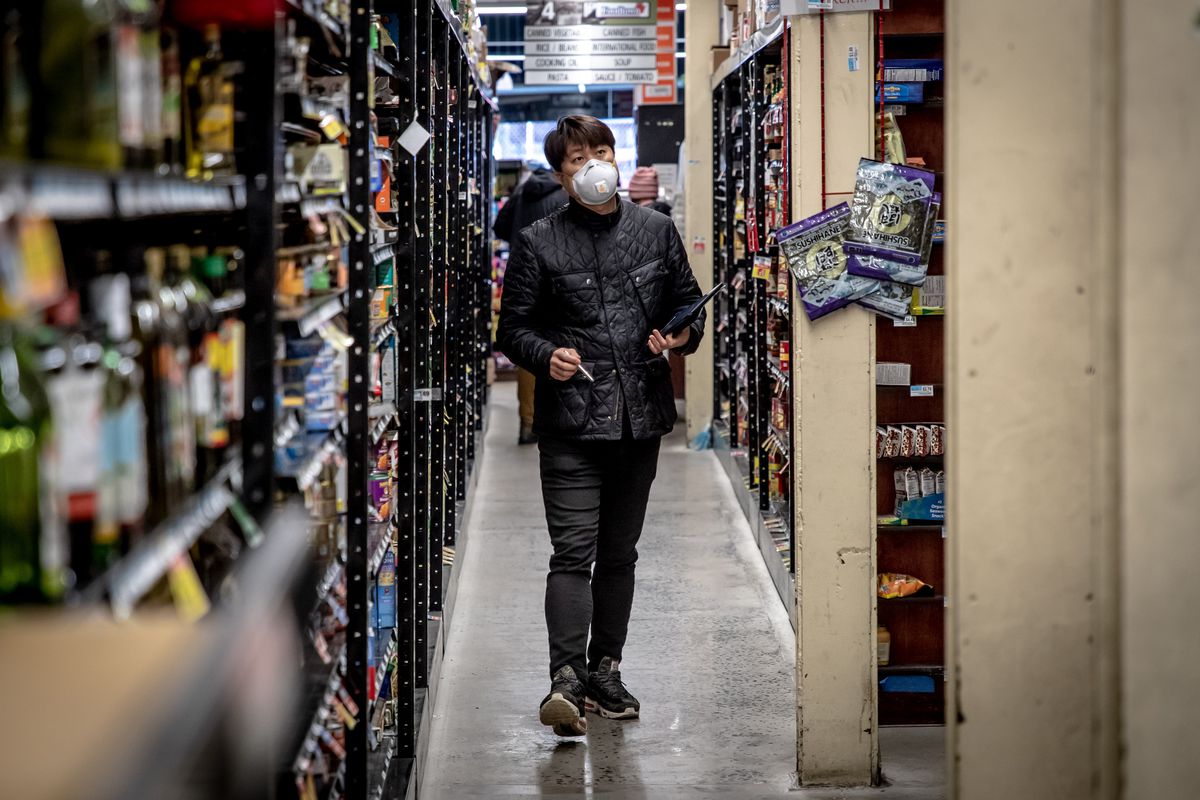 A man wearing a mask checks inventory in a supermarket