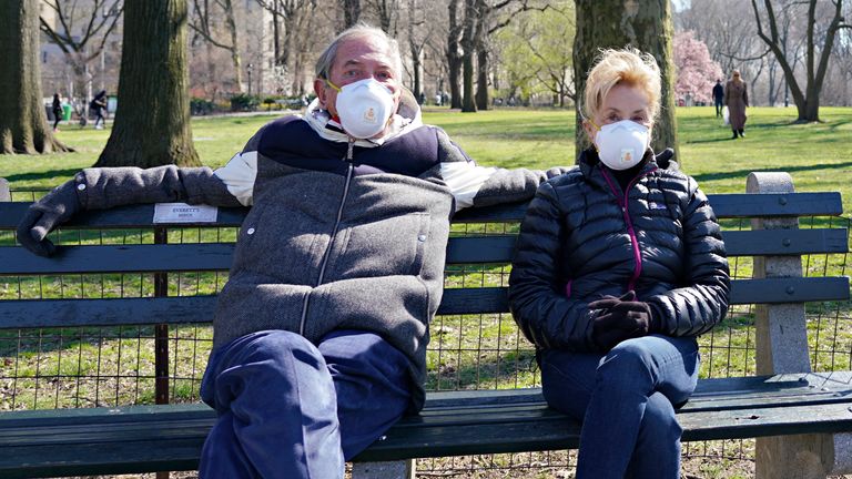 A man and woman wear protective masks in Central Park as the coronavirus continues to spread across the United States on March 26, 2020 in New York City