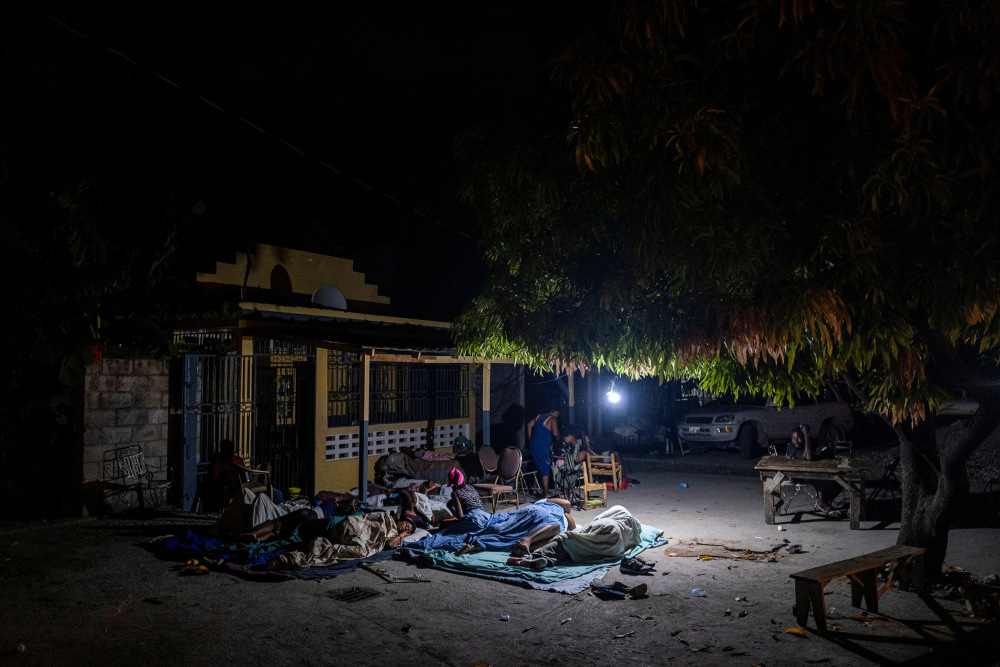 People rest outside their home after tremors shook buildings, following Saturday's earthquake in Les Cayes, Haiti, Aug. 19.
