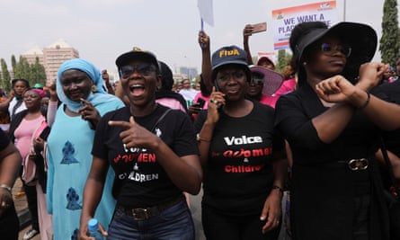 Women with protests signs march outside against legislative bias in Abuja, Nigeria