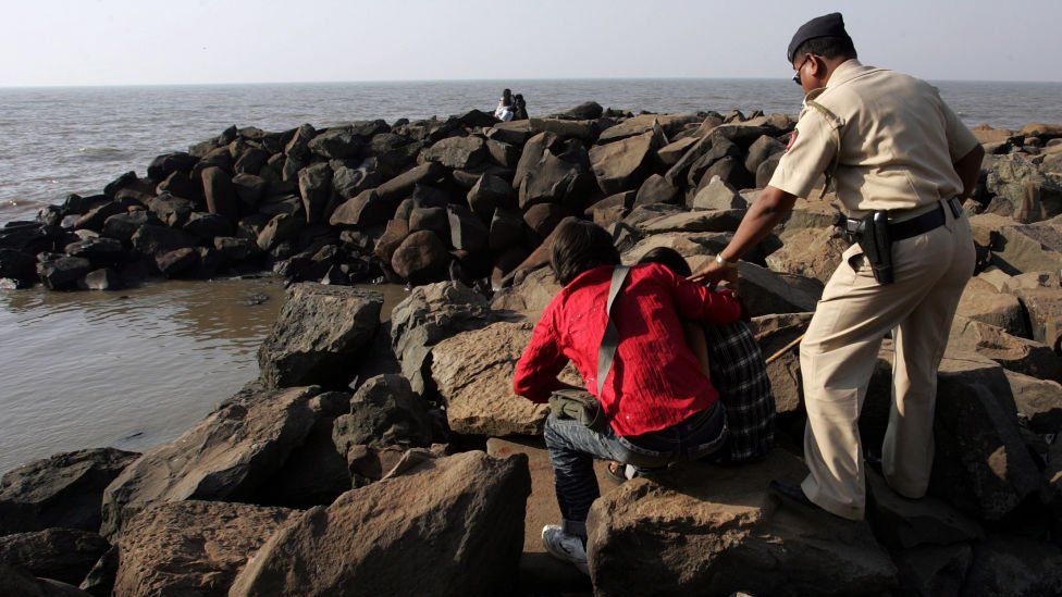 MUMBAI, INDIA - FEBRUARY 11, 2008: Couples - A Police constable from Beat Number three of Bandra police station forces the couples cuddling on the rocks near the Searock Hotel on Bandstand on Monday evening.