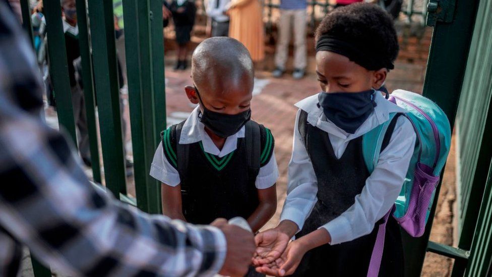 Students at a Johannesburg school sanitise their hands at the school entrance in 2021