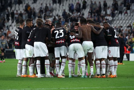 Milan players huddle on the pitch at the Allianz Stadium in Turin following victory against Juventus.