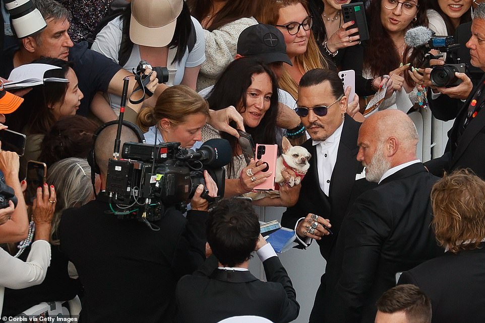 Johnny! According to reports, throngs of onlookers shouted 'Johnny!' as Depp, in purple-hued sunglasses signed autographs and edged back into the spotlight