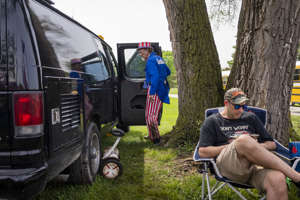 A man dressed as Uncle Sam packs up his van before a campaign rally of former president and Republican presidential candidate Donald Trump, which was postponed due to severe weather.