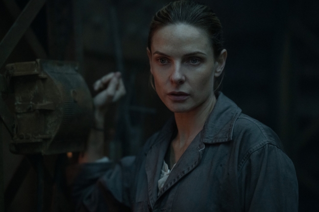 Rebecca Ferguson holds onto a mechanical lever in Silo.