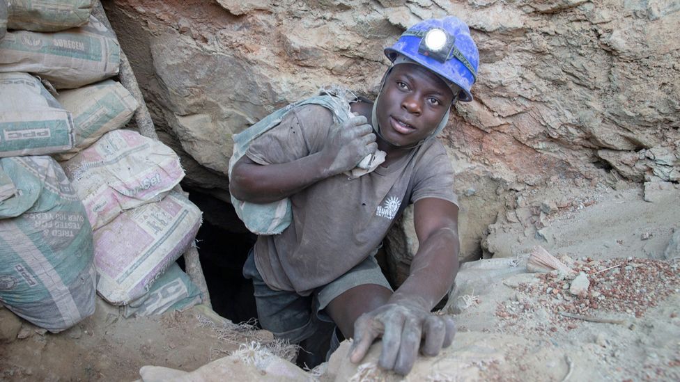 A miner carries a bag with ore as he comes out of a mine shaft in Shamva, Zimbabwe - Friday 9 June 2023