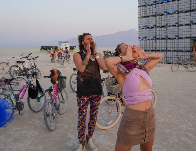 Kris Elsley and Dan McCann of Toronto howl at sunset, a traditional ritual at Burning Man.