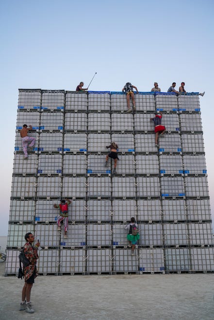 People climb atop a piece of art at Burning Man.