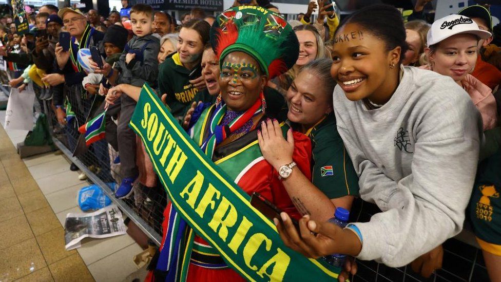 Fans react as they wait for the arrival of the South Africa team after winning the Rugby World Cup