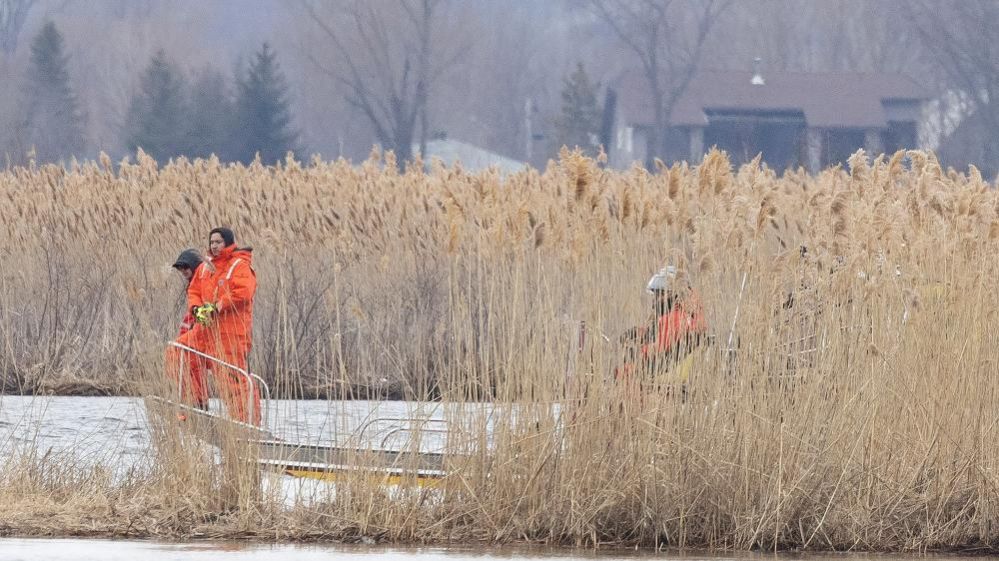 Local firemen search the marshland for bodies in Akwesasne, Quebec, Canada