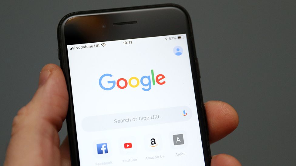 Google search function seen on phone held by a hand