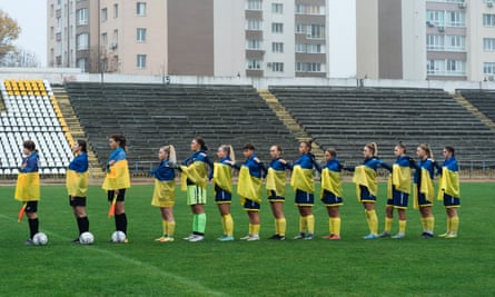 The match officials and the Mariupol players listen to the Ukrainian anthem before the start of the match in Vinnytsia, Ukraine.