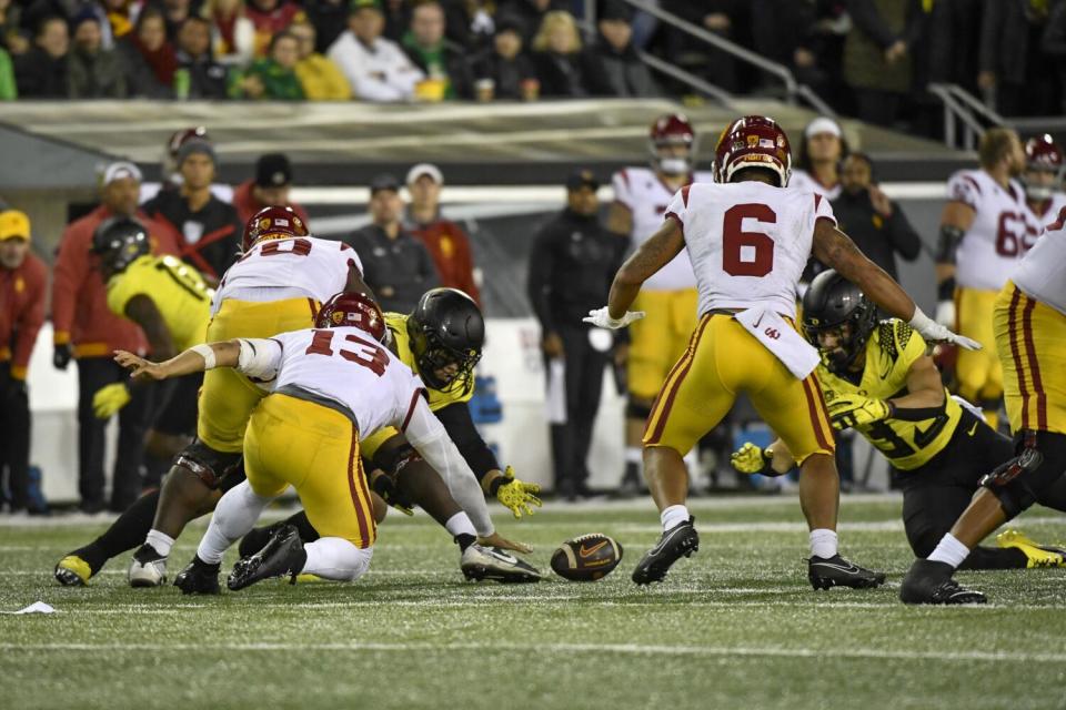 Oregon defensive back Evan Williams dives for a fumble as USC quarterback Caleb Williams tries to recover the ball.