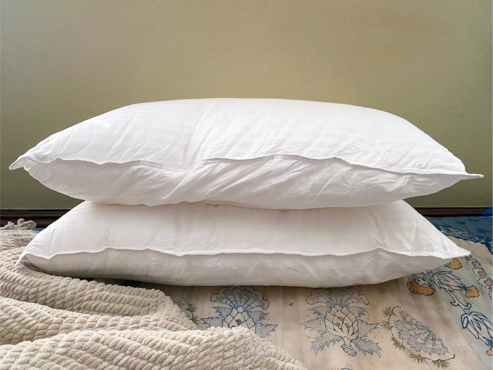 Two white Beckham Hotel pillows sit flat on top of each other on a bed.