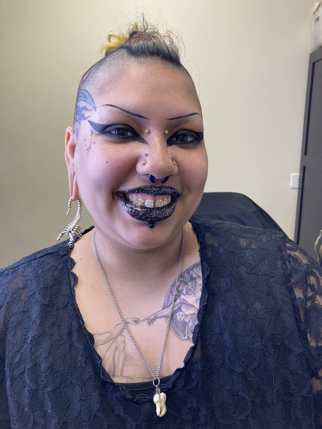 Michelle Sanchez shows off her tooth gems with a big smile after cosmetologist Libby Kerfman applied sparkly lip gloss to add even more shine to the overall look. Her front two teeth have chandelier designs, which require 16 gems.