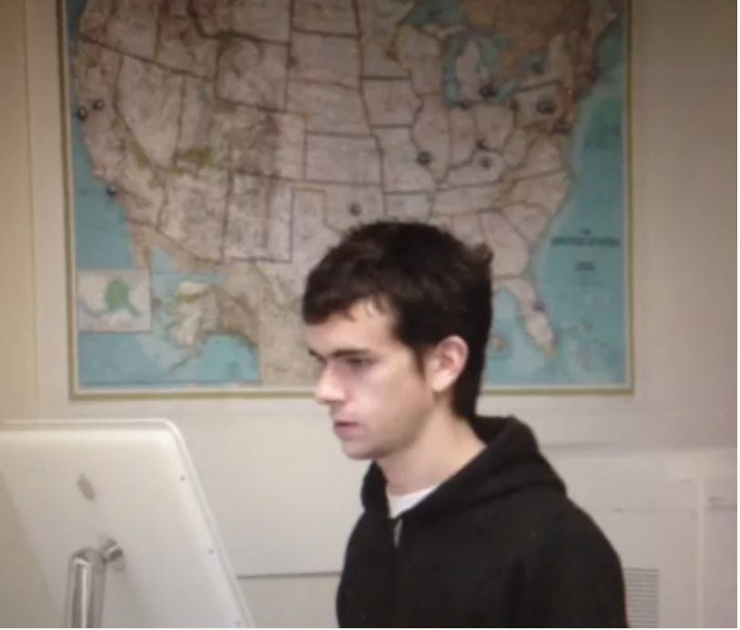 A young Jack Dorsey in front of a computer with a map of America behind him.