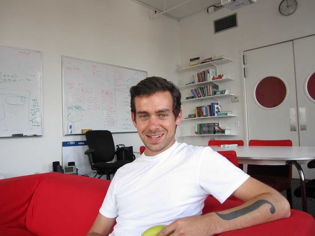 Young Jack Dorsey sitting on a red couch.