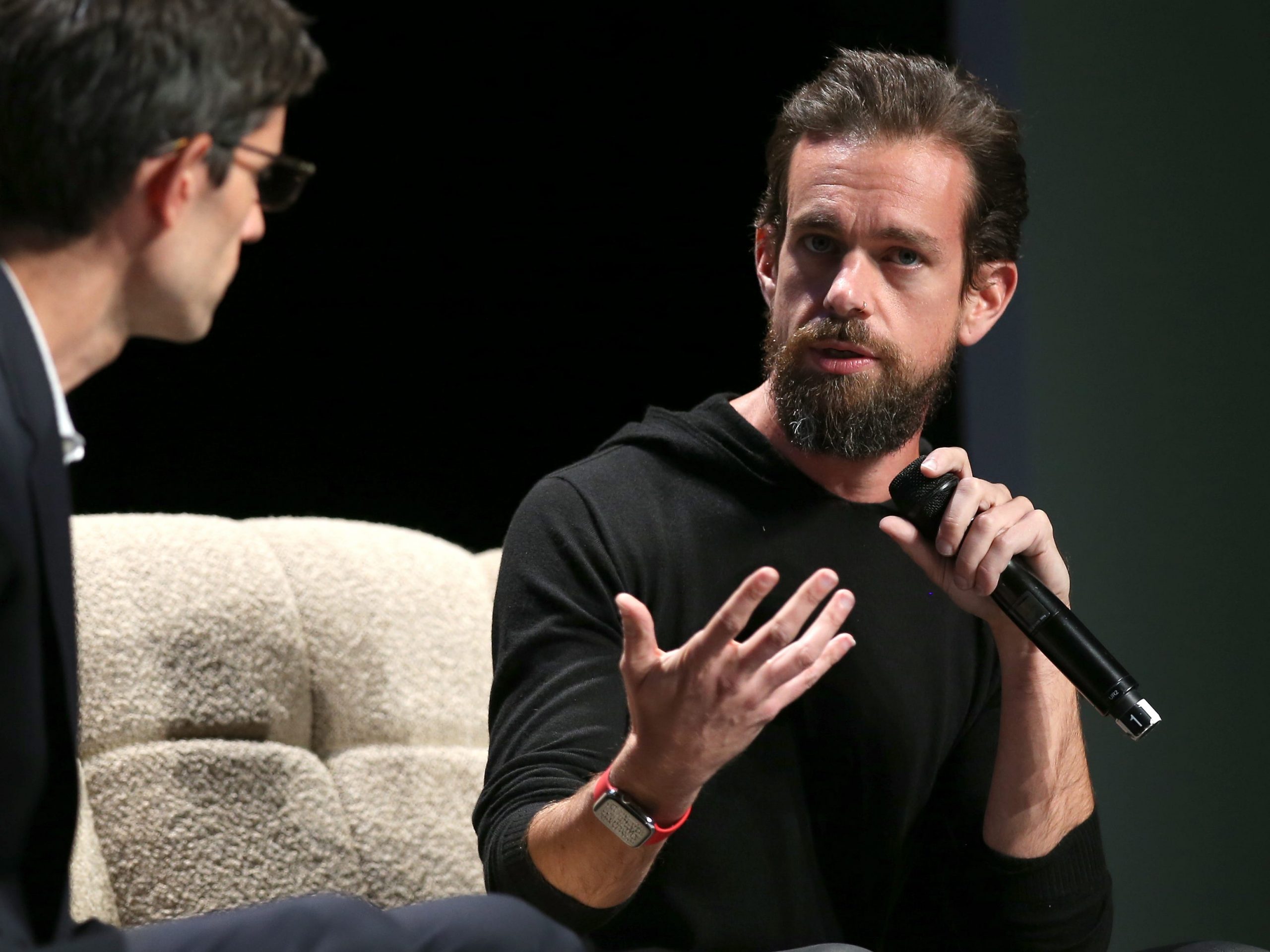 Jack Dorsey speaking to another man with a microphone.