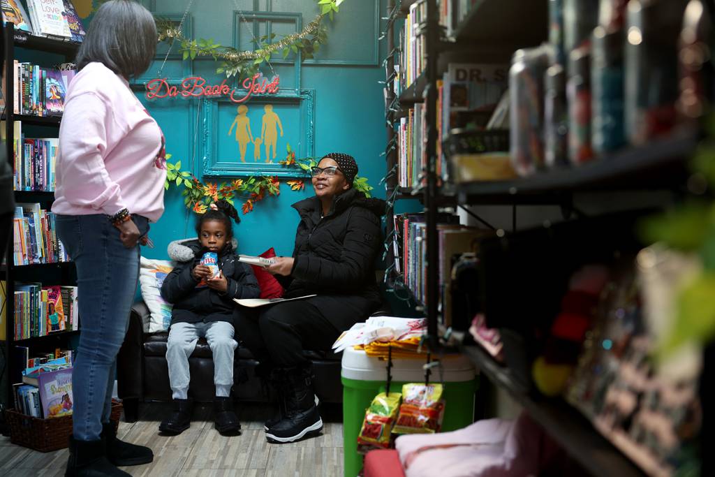 Lanyha Pascascio, 7, and her grandmother, Lesa Beckom, talk with Verlean Singletary, left, at Da Book Joint, 330 E. 51st St., Jan. 20, 2024, in Chicago. Singletary had planned to close the business at the end of 2023 but will keep it going. 