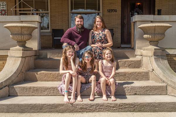 Kevin and Sara Brown and their children, from left, Carleigh, Lily and Ailene Brown, sit on the stoop of their home, the Henry Klein House in Blue Island.