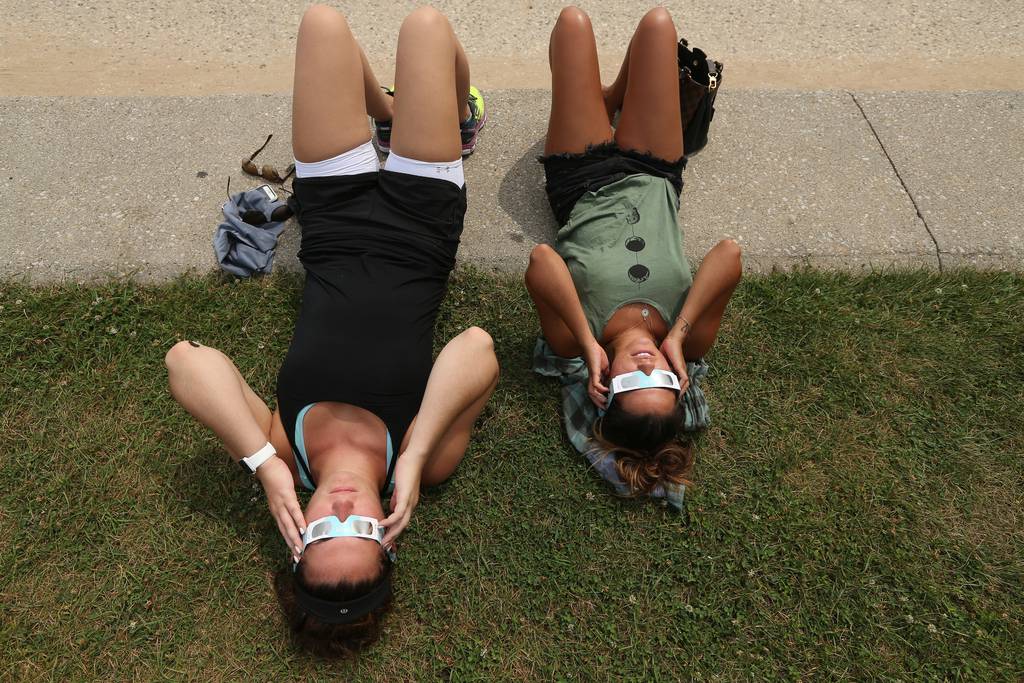 Molly Ryan, 25, left, and Giselle Hilgert, 24, both of Chicago, view the eclipse Aug. 21, 2017, from North Avenue Beach.