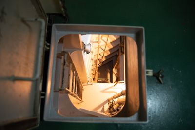 A hatch leading below deck in the Ocean Link. The room below is brightly illuminated.