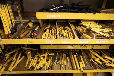 A large collection of bright yellow tools stored on shelves.