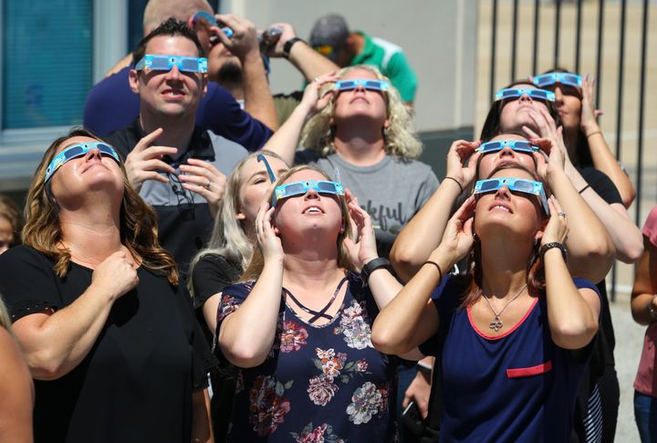 People watch the solar eclipse in Fort Worth, Texas, in 2017. Eclipse viewers are advised to wear specialized eyewear while looking at the sun to prevent eye damage. Normal sunglasses are not enough. 