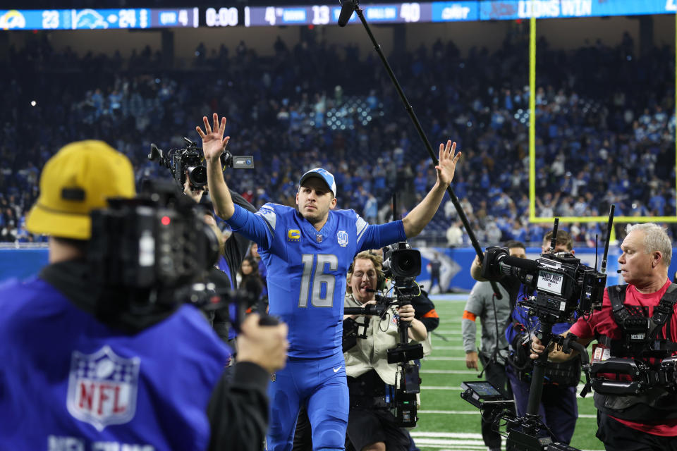 DETROIT, MI - JANUARY 14:  Detroit Lions quarterback Jared Goff (16) gestures to fans as he runs off of the field with the media following him at the conclusion of an NFL NFC Wild Card playoff football game between the Los Angeles Rams and the Detroit Lions on January 14, 2024 at Ford Field in Detroit, Michigan.  (Photo by Scott W. Grau/Icon Sportswire via Getty Images)