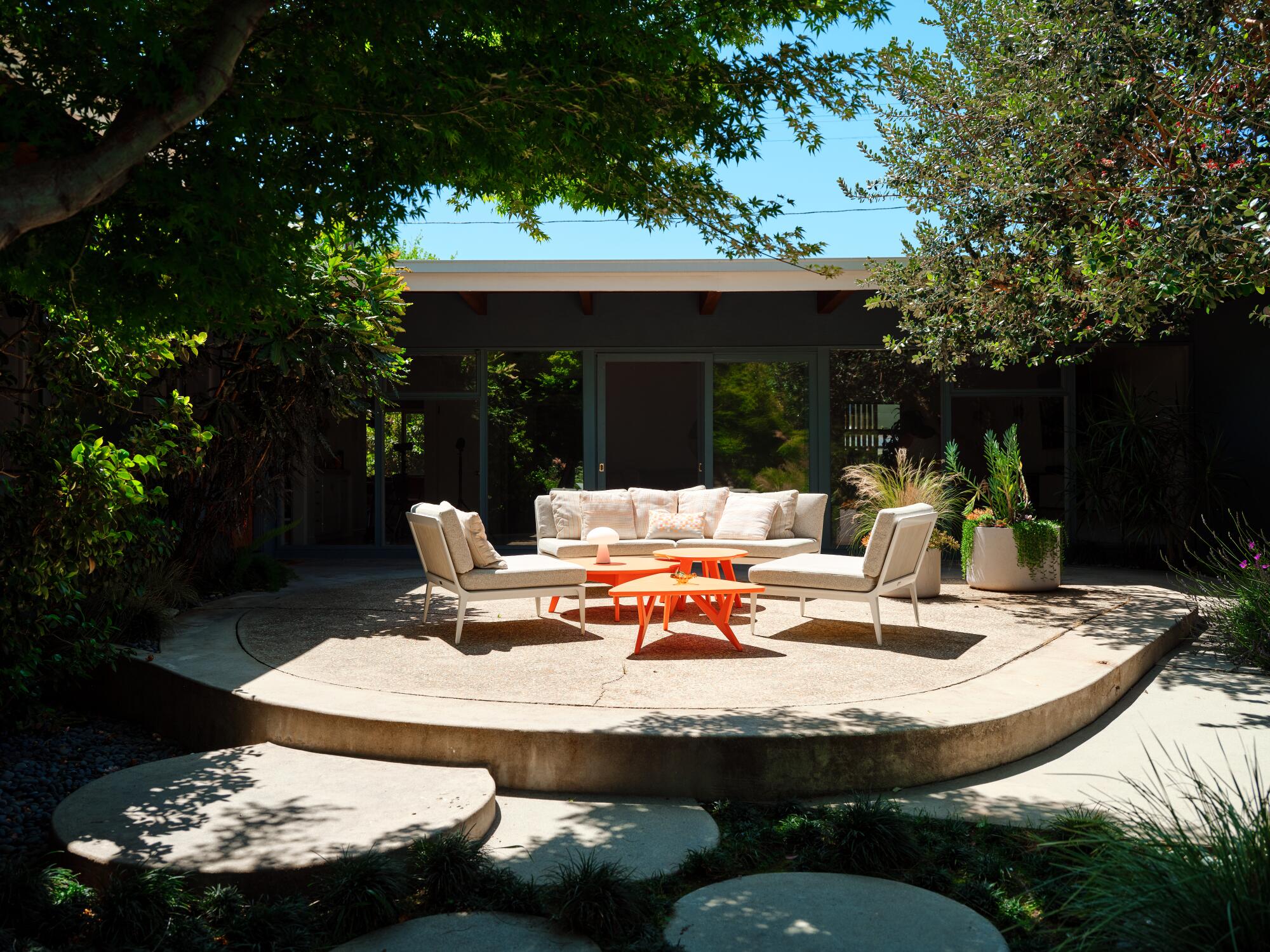 White and orange outdoor furniture on a concrete patio.