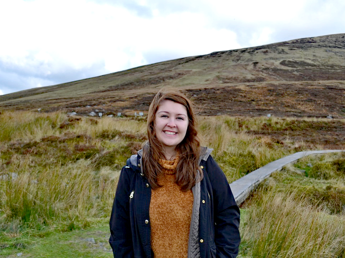 alexis standing in front of rolling green hills in ireland