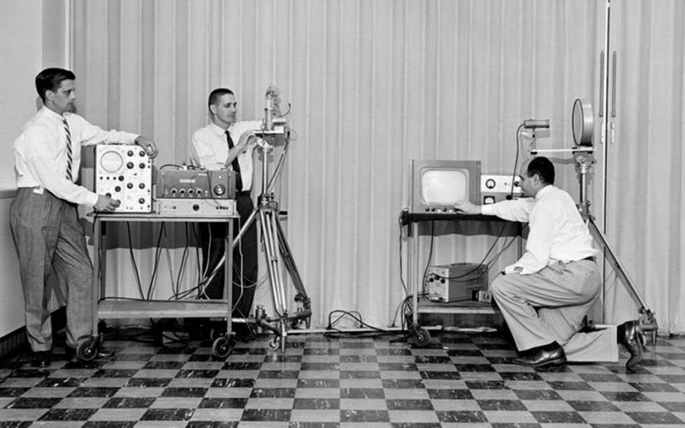 A group of men next to devices.  