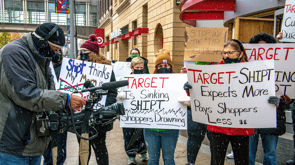 A photograph showing protesters gathered in front of a Target store with signs bearing messages about Shiptu2019s treatment of its workers.