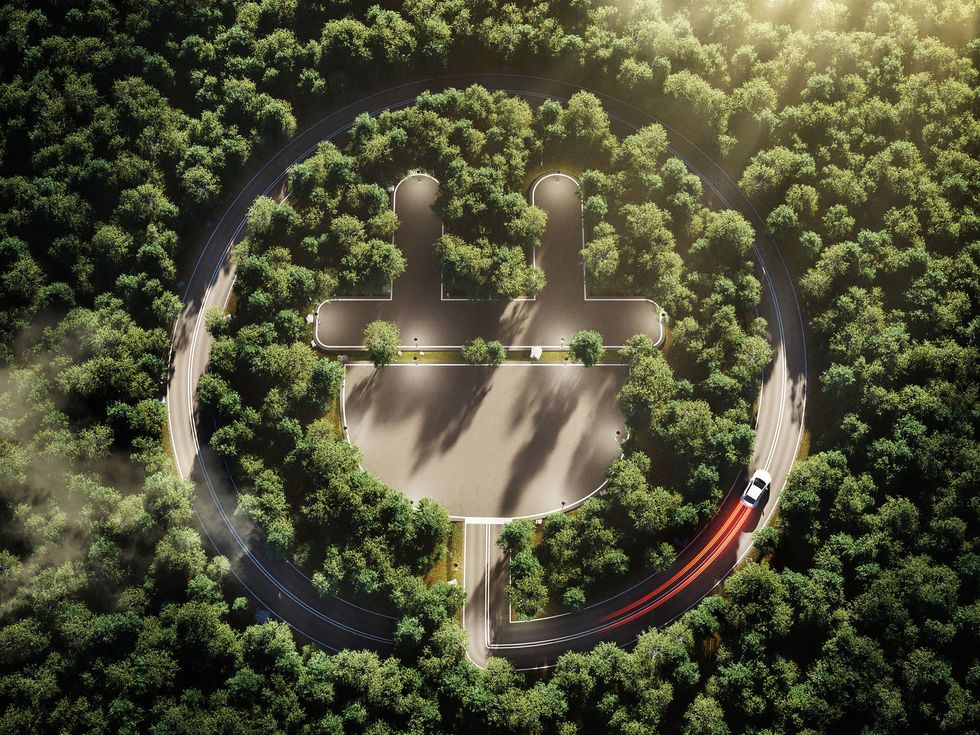 aerial view of trees and road in the shape of a electric plug