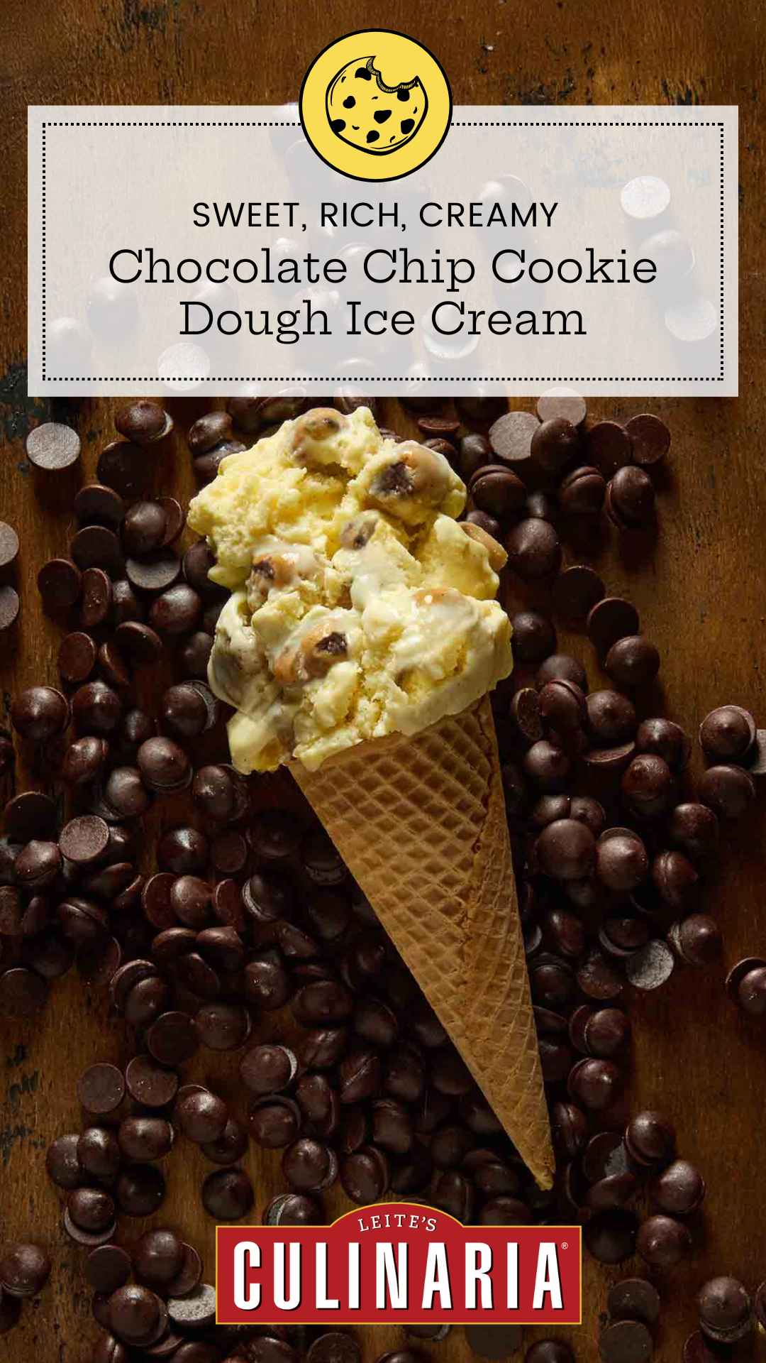 A sugar cone of chocolate chip cookie dough ice cream lying on a bed of chocolate chips.