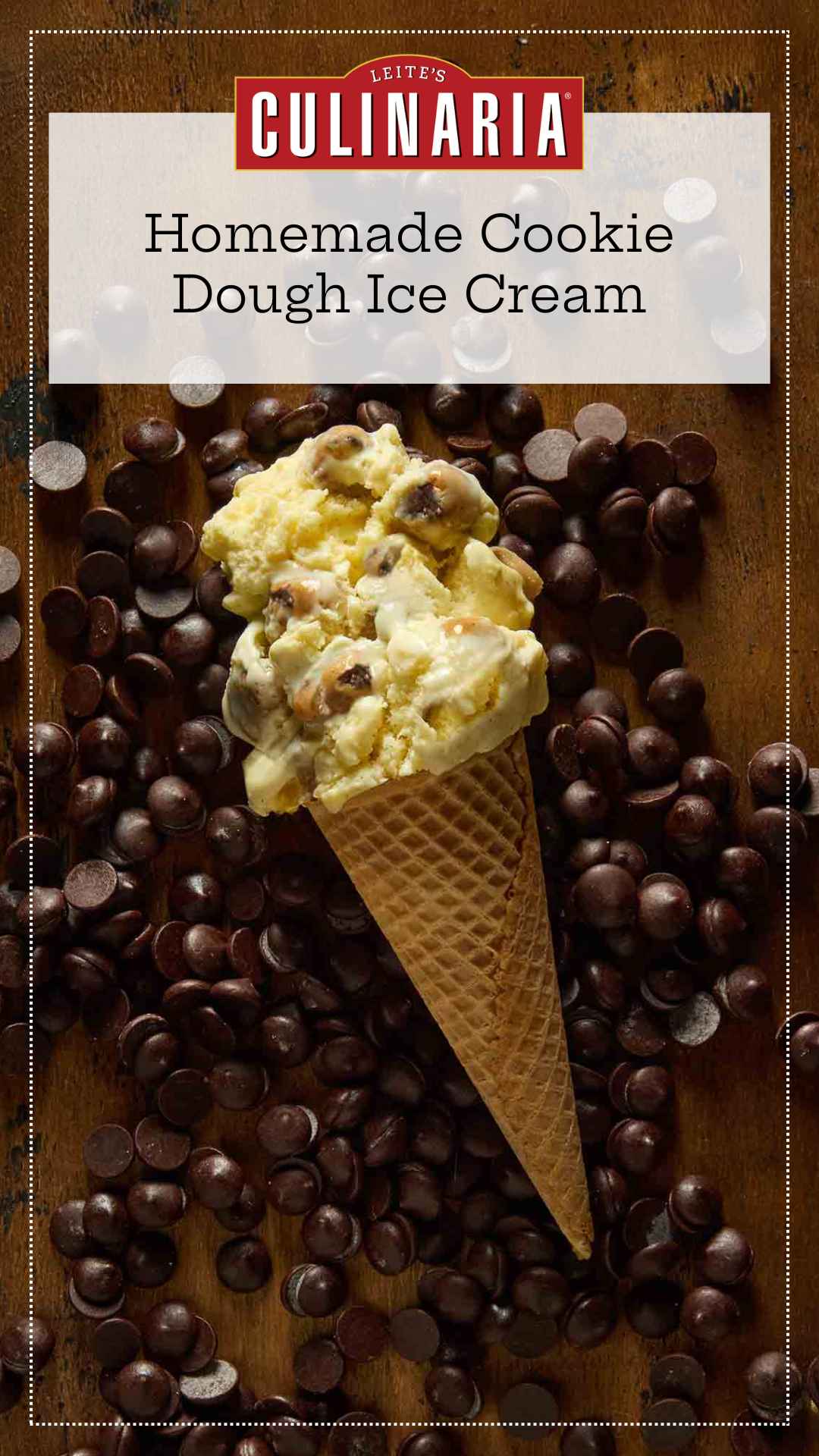 A sugar cone of chocolate chip cookie dough ice cream lying on a bed of chocolate chips.