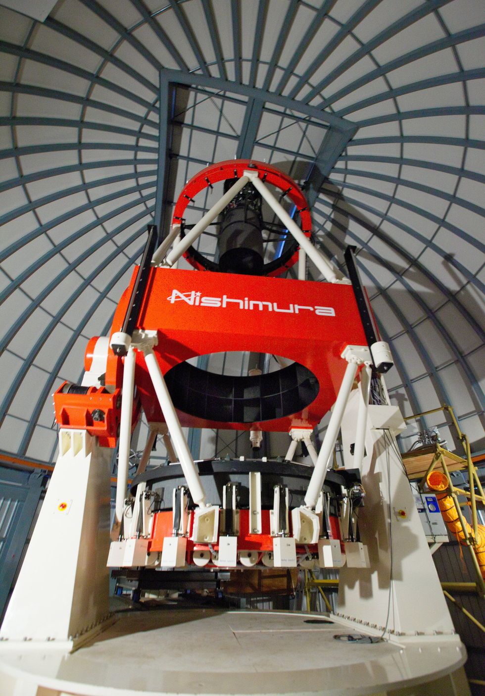 Photo of a large red and white apparatus inside a domed structure.