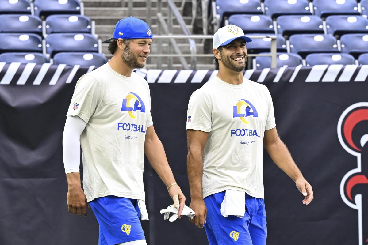 Rams quarterbacks Matthew Stafford (left) and Jimmy Garoppolo walk onto the field before game.