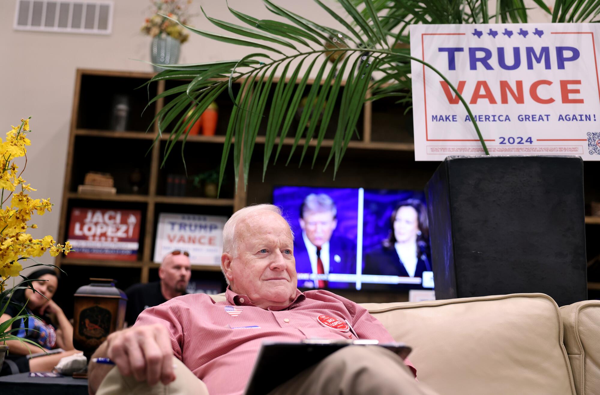 A man leans back on a couch while watching 