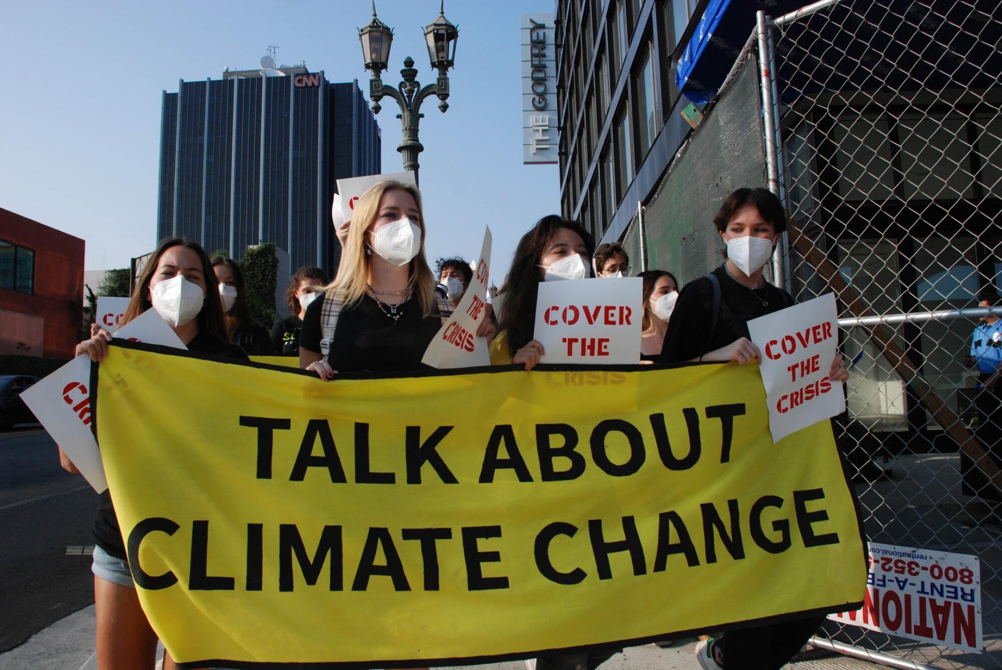 Protesters hold a banner that reads, "Talk about climate change"  