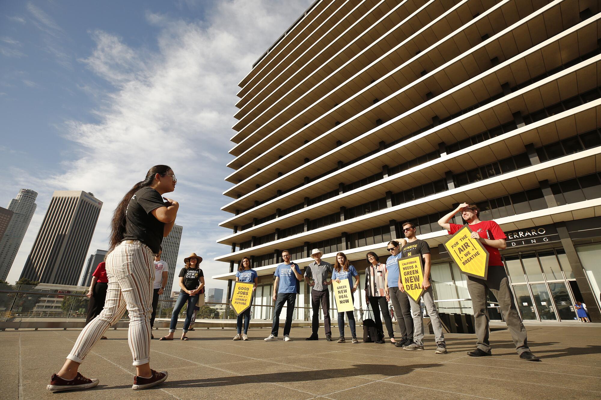 People holding protest signs stand outside LADWP headquarters.