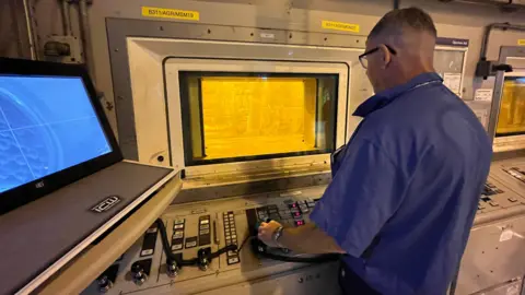 BBC In Sellafield's fuel handling plant, nuclear fuel is moved by robotic arms that are controlled from behind metre-thick, lead-lined glass