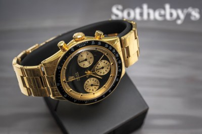 A gold and black Rolex wristwatch with three mini faces and numbers on the outside. 