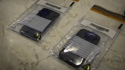 Europol Two phones in plastic bags on a table 