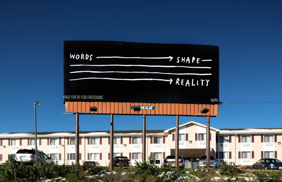 a black billboard wign with white text reading, "words shape reality"