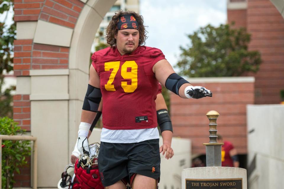 USC offensive lineman Jonah Monheim taps a sword before football practice.