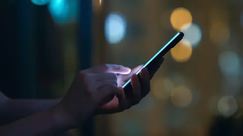 Getty Images A close up of a person's hands holding a phone. 