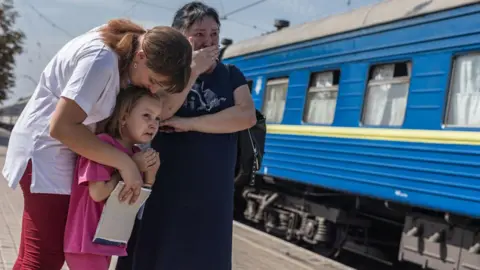 Getty Images Crying Ukrainians near a train in Pokrovsk